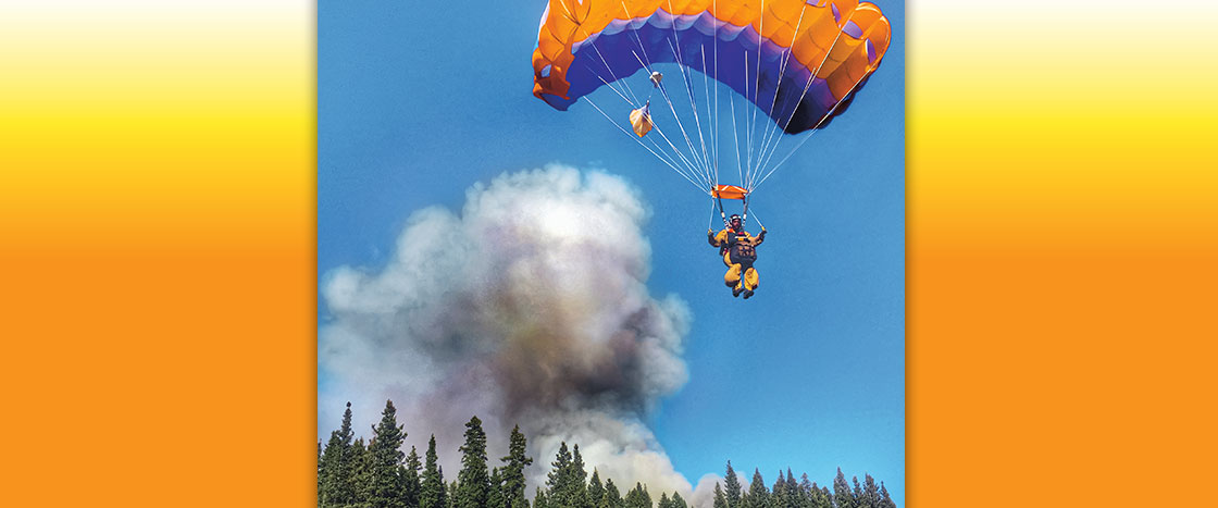 a skydiver hovering over a large cloud of smoke